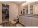 Bathroom featuring white cabinets, dual mirrors, dual sinks, granite counters, and a walk-in closet at 88 Oxford Ln, Kingston, GA 30145