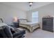 Bedroom featuring neutral walls, large window, ceiling fan, comfortable bed, and dark dresser at 88 Oxford Ln, Kingston, GA 30145