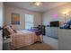 Bright bedroom featuring a window, a TV set, and a bed with pink polka dot covers at 88 Oxford Ln, Kingston, GA 30145