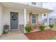Inviting front porch featuring decorative hanging plants, gray door with wreath and rocking chairs on a stone bed at 88 Oxford Ln, Kingston, GA 30145