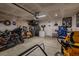 Spacious garage featuring motorbikes, a lawnmower, and a storage mezzanine at 88 Oxford Ln, Kingston, GA 30145