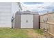 Durable backyard shed with white double doors, offering additional storage space, and located adjacent to the fence at 88 Oxford Ln, Kingston, GA 30145