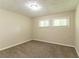 Neutral bedroom featuring carpet flooring, two windows with blinds, and a light fixture at 2304 Ousley Ct, Decatur, GA 30032