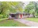 Inviting single-story home featuring a covered carport, manicured lawn, and an eye-catching red front door at 2304 Ousley Ct, Decatur, GA 30032