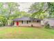 Charming single-story home with a bright red front door, covered carport, and well-maintained lawn at 2304 Ousley Ct, Decatur, GA 30032