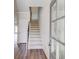 Bright entryway with hardwood floors, a white door, staircase with carpet runner, and gray painted trim at 2378 Morgan Creek Rd, Buford, GA 30519