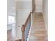 Carpeted staircase with a wooden handrail and black iron balusters at 2378 Morgan Creek Rd, Buford, GA 30519