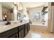 Bright bathroom featuring a double vanity, soaking tub with window, and modern fixtures at 3482 Willow Meadow Ln, Douglasville, GA 30135