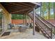 Covered stone patio featuring outdoor seating and an upper wooden deck, great for entertaining at 358 Nature Brook Se Walk, Smyrna, GA 30082