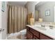 Well-lit bathroom featuring a neutral-toned shower curtain, vanity with sink, mirror, and essential bathroom accessories at 358 Nature Brook Se Walk, Smyrna, GA 30082