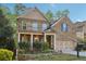 Charming two-story brick home featuring a welcoming front porch and a well-manicured front yard with beautiful landscaping at 358 Nature Brook Se Walk, Smyrna, GA 30082