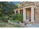 Charming front porch detail with a brick facade, decorative columns, and beautiful, mature landscaping at 358 Nature Brook Se Walk, Smyrna, GA 30082