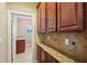 View of a spacious pantry featuring wooden cabinets, granite countertops, and decorative tile backsplash at 358 Nature Brook Se Walk, Smyrna, GA 30082