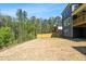 A spacious backyard featuring privacy fence with a lush wooded backdrop, and the home's exterior at 461 Maypop Ln, Woodstock, GA 30188