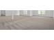 This open basement area features neutral carpeting, bright windows, and plenty of open space at 461 Maypop Ln, Woodstock, GA 30188