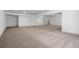 This open basement area features neutral carpeting, open space, and a staircase at 461 Maypop Ln, Woodstock, GA 30188