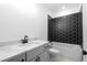 This modern bathroom features a white vanity, a sink, and black tile in the shower and tub at 461 Maypop Ln, Woodstock, GA 30188