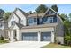 Charming two-story home featuring a brick facade, gray siding, and a two-car garage at 461 Maypop Ln, Woodstock, GA 30188