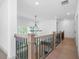 Upstairs hallway with wooden banister, modern light fixture and plenty of natural light at 461 Maypop Ln, Woodstock, GA 30188