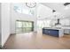 Bright, open-concept living room with hardwood floors, vaulted ceilings, and a kitchen island with waterfall countertops at 461 Maypop Ln, Woodstock, GA 30188