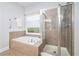 Bathroom featuring soaking tub with tile surround, shower, and a window at 2069 Willow Chase Ct, Tucker, GA 30084