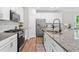 Modern kitchen boasting granite countertops, white cabinetry, stainless steel appliances, and wood floors at 3377 Park Pointe Cir, Scottdale, GA 30079