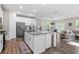 Open-concept kitchen featuring a large island with granite countertops, stainless steel appliances, and wood floors at 3377 Park Pointe Cir, Scottdale, GA 30079