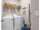 Bright laundry room with modern washer and dryer, wire rack shelves, and cleaning supplies at 3377 Park Pointe Cir, Scottdale, GA 30079