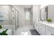 Bright bathroom features a walk-in shower with glass doors, tiled floors, and double sinks at 3377 Park Pointe Cir, Scottdale, GA 30079