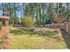 Spacious backyard featuring lush green grass, mature trees, and a wooden fence, perfect for outdoor activities at 504 Baltimore Sw Ave, Lilburn, GA 30047