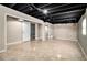 Large finished basement with tiled flooring, storage, and exposed ceiling at 504 Baltimore Sw Ave, Lilburn, GA 30047
