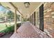 Spacious covered porch with tiled floor and hanging lanterns, ideal for enjoying outdoor living at 504 Baltimore Sw Ave, Lilburn, GA 30047