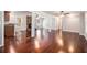 Open-concept living room featuring hardwood floors, a brick fireplace, and a seamless flow to the kitchen at 504 Baltimore Sw Ave, Lilburn, GA 30047