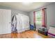 This bedroom features hardwood floors, a closet covered by fabric, and a window illuminating the interior at 846 Orris Ln, Mableton, GA 30126