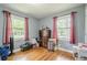 Bright bedroom with hardwood floors, complemented by two windows and red curtains offering ample natural light and charm at 846 Orris Ln, Mableton, GA 30126