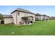 View of the home's backyard with a covered patio and a lush green lawn at 2511 Day Break Way, Dacula, GA 30019