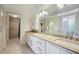 Bright bathroom featuring a double sink vanity, granite countertops, laundry area, and accessible shower at 2637 Peachtree Ne Rd # 407, Atlanta, GA 30305