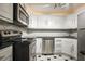 Galley kitchen featuring white cabinets, stainless steel appliances, and black countertops at 2637 Peachtree Ne Rd # 407, Atlanta, GA 30305