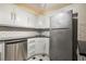Galley kitchen featuring white cabinets, black countertops, and stainless steel refrigerator at 2637 Peachtree Ne Rd # 407, Atlanta, GA 30305