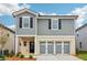 Charming two-story home with gray siding, black shutters, and a light stone garage with a three-car gray door at 2762 Aralynn Way, College Park, GA 30337