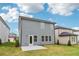 This image shows the rear exterior of the house with a gray vinyl siding, patio and green grass at 2762 Aralynn Way, College Park, GA 30337