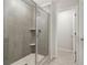 Modern bathroom shower featuring gray tiling, glass doors, and a built-in shelf at 2764 Aralynn Way, College Park, GA 30337