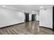Spacious basement featuring modern wood-look flooring, white walls, and black trim at 3661 W Potomac Dr, East Point, GA 30344