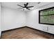 Minimal bedroom with wood floor, ceiling fan, black trim window, and ample natural light at 3661 W Potomac Dr, East Point, GA 30344