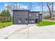 Modern dark gray home exterior with a concrete driveway and a well-manicured lawn at 3661 W Potomac Dr, East Point, GA 30344