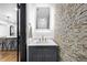 Stylish powder room featuring stone accent wall, modern vanity, and sleek fixtures, open to kitchen at 3661 W Potomac Dr, East Point, GA 30344