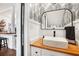 Stylish powder room with a vessel sink, wood countertop, modern mirror and leaf-patterned wallpaper at 105 Park Ridge Cir, Marietta, GA 30068