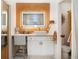 Charming bathroom boasts a vanity with lighted mirror and adjacent toilet with patterned wallpaper feature at 105 Park Ridge Cir, Marietta, GA 30068