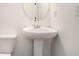 Bathroom featuring a pedestal sink and a toilet, illuminated by a vanity mirror at 3095 Bonnes Dr, Lithonia, GA 30038