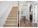 Inviting foyer with a carpeted staircase and hardwood flooring, enhanced by archway details at 3095 Bonnes Dr, Lithonia, GA 30038